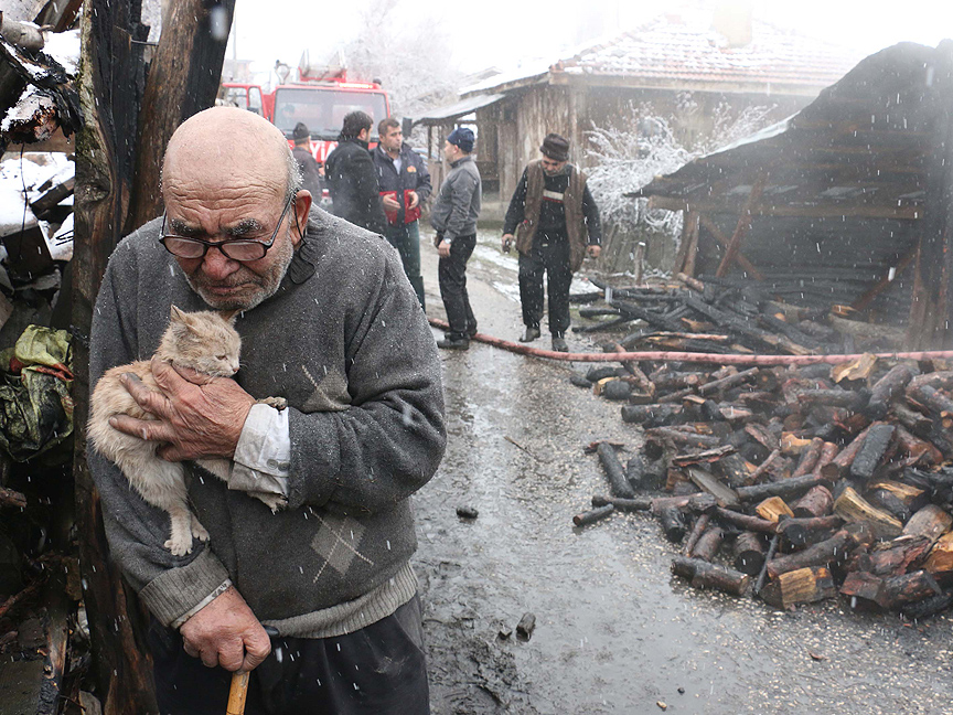 83 yaşındaki Ali Meşe yangından itfaiye ekipleri tarafından kurtarılan kedisine sarılarak evinin yanmasını izlemişti.